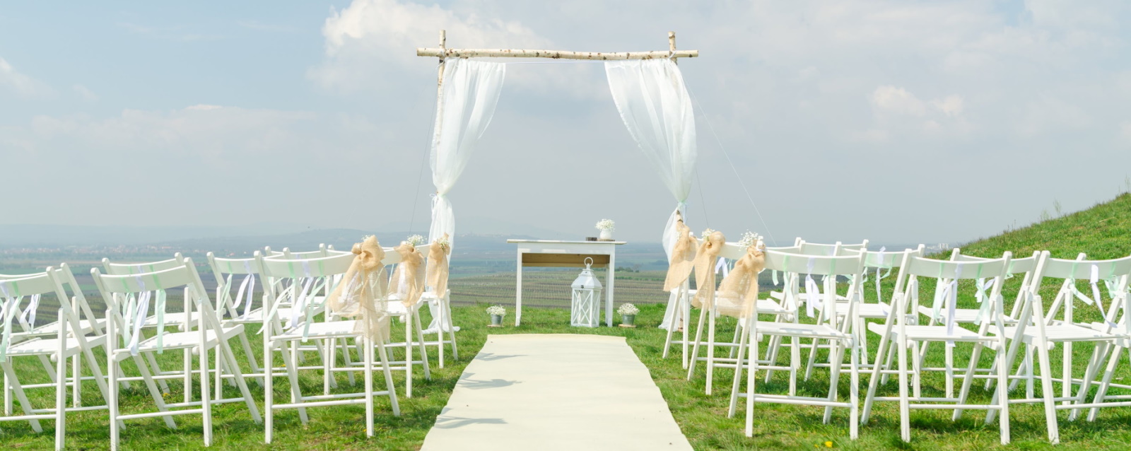 White chairs outdoor ceremony setup
