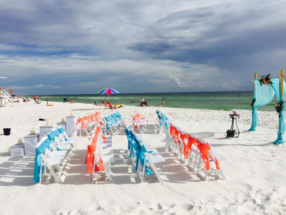 Coral and teal sashes at beach ceremony